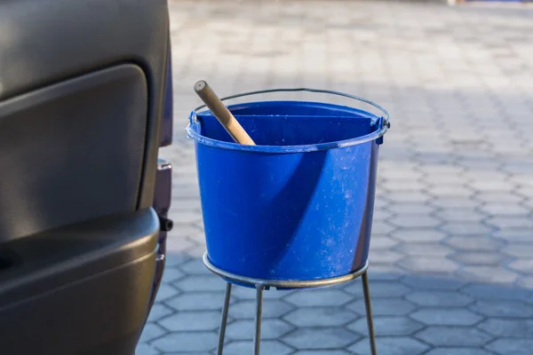 Blue bucket with water at a gas station — Stock Photo, Image