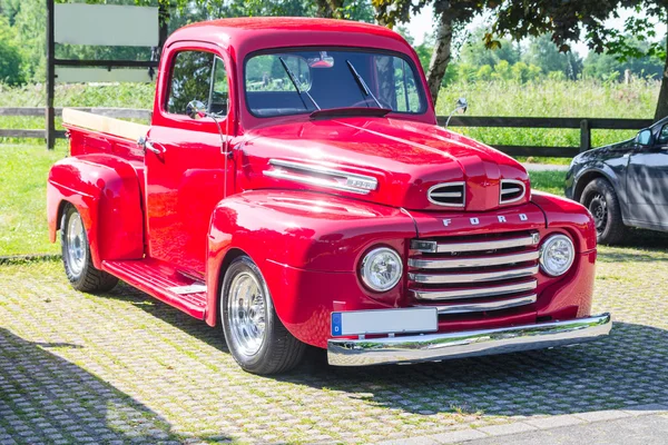 Eski bir park yerinde kırmızı Ford vintage kamyonet yenilenmiş.