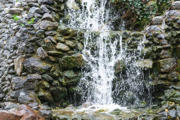 Pequeña cascada, cascada que fluye sobre rocas musgosas — Foto de Stock