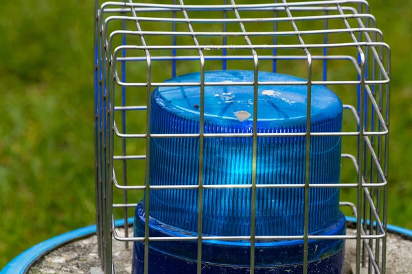 Blue flashing light in the wire cage — Stock Photo, Image