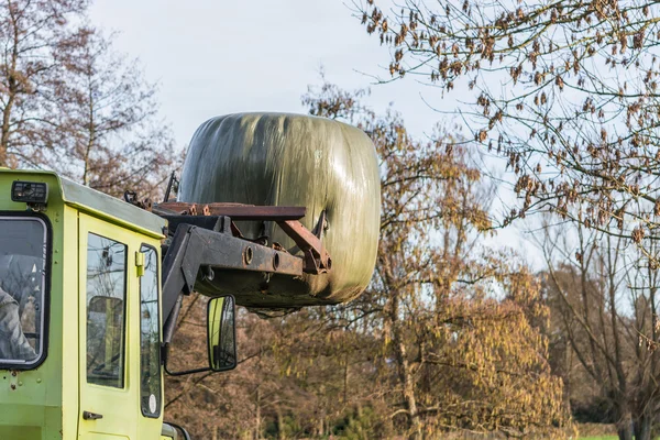 Bale de transporte de heno con una vieja máquina de granja . —  Fotos de Stock