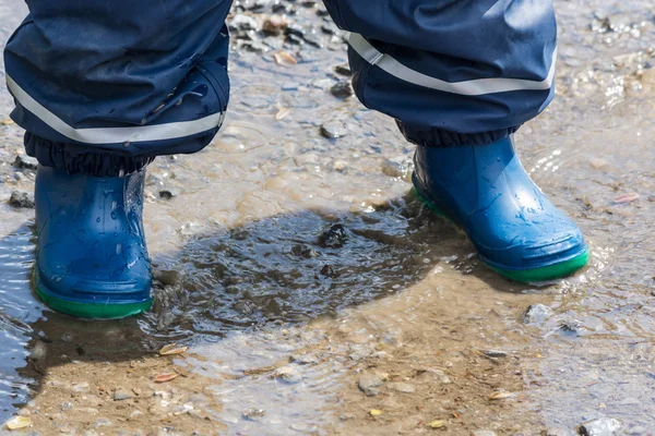 Crianças pernas em botas de borracha azul — Fotografia de Stock