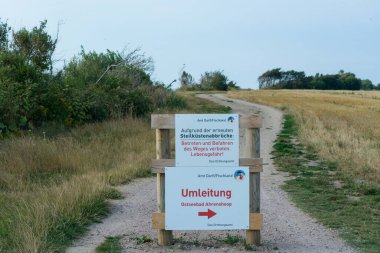Almanca yazılı beyaz uyarı işareti - Darss 'taki Baltık Denizi' ndeki kayalıklardan sakının