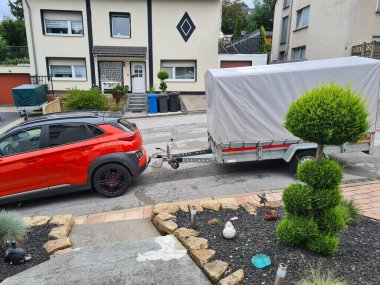 Gri tenteli tek dingil römorklu sıkıştırılmış SUV.