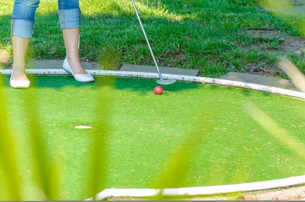 Крупный план Мини-гольф отверстие с битой и мячом — стоковое фото
