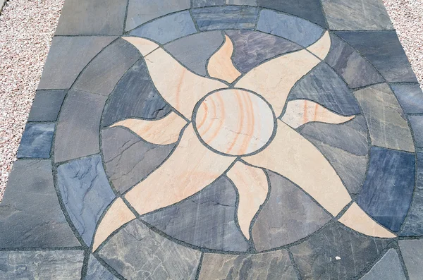 Stone floor tiles with sun motif — Stock Photo, Image