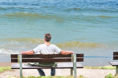  Man on bench, looking out to sea