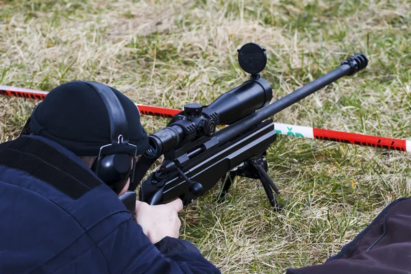 Military sniper aims at a target