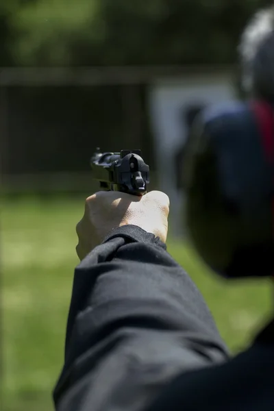 Hombre practicando tiro con un arma — Foto de Stock