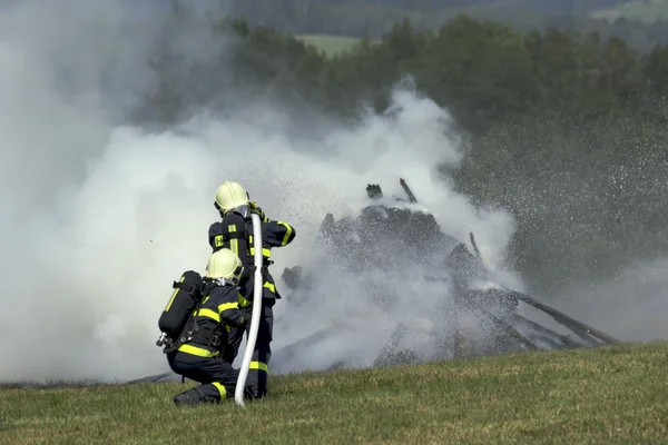 Firefighters extinguish fire fire vehicle — Stock Photo, Image