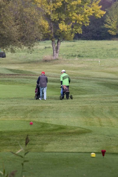 People move around the golf course