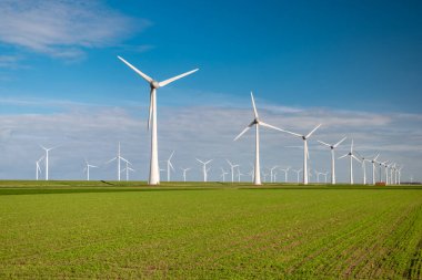 Bulutları ve mavi gökyüzü olan off-shore yel değirmeni parkı, okyanusta rüzgar türbinli drone hava manzaralı yel değirmeni.
