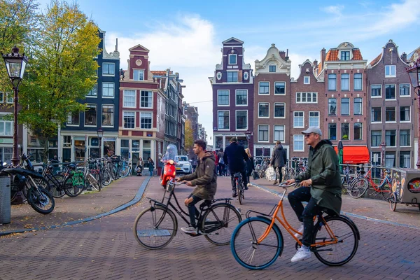 Amsterdam Niederlande im Herbst Herbstsaison in der Stadt entlang der holländischen Kanäle mit bunten Bäumen rund um die Kanäle und Menschen, die sich in der Sonne entspannen draußen auf der Straße, weil das Restaurant — Stockfoto