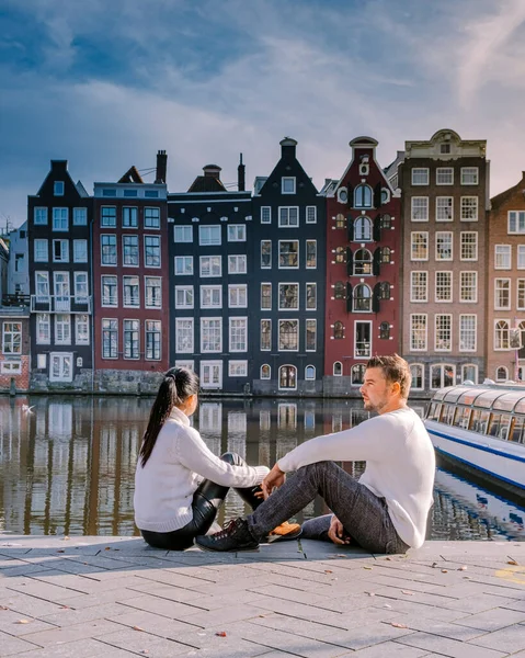 Amsterdam Nederland in het najaar bezoeken echtpaar mannen en vrouwen in oktober de cituy van Amsterdam met oranje kleuren langs het kanaal — Stockfoto