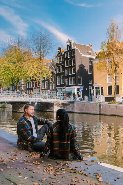 Amsterdam Países Bajos durante la temporada de otoño, pareja de hombres y mujeres visitan la ciudad de Amsterdam con colores naranjas junto al canal en octubre —  Fotos de Stock