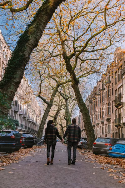 Amsterdam Holandia jesienią jesienią, para mężczyzn i kobiet odwiedza miasto Amsterdam w pomarańczowych kolorach wzdłuż kanału w październiku — Zdjęcie stockowe