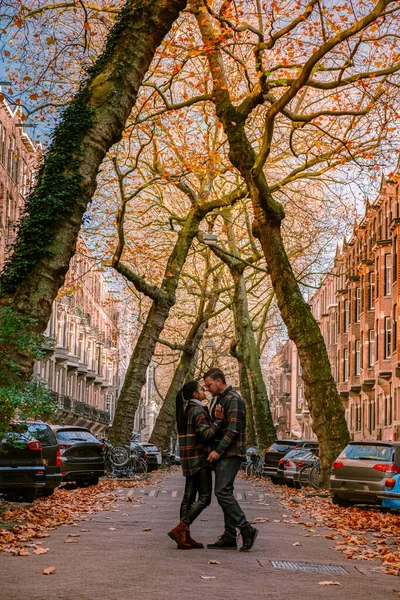 Amsterdam Pays-Bas pendant la saison automnale, deux hommes et une femme visitent le cituy d'Amsterdam avec des couleurs orange le long du canal en octobre — Photo