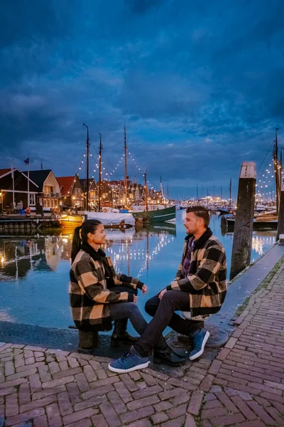 Urk Flevoland Holland, pareja de hombres y mujeres observando la puesta de sol en el pequeño pueblo pesquero puerto de Urk Países Bajos — Foto de Stock
