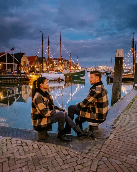 Urk Flevoland Holland, pareja de hombres y mujeres observando la puesta de sol en el pequeño pueblo pesquero puerto de Urk Países Bajos — Foto de Stock