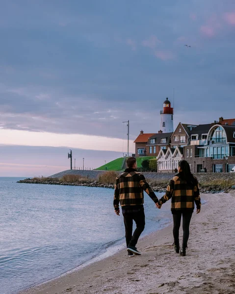 Urk Flevoland Holland, para mężczyzn i kobiet oglądających zachód słońca w małym porcie rybackim Urk Netherlands — Zdjęcie stockowe