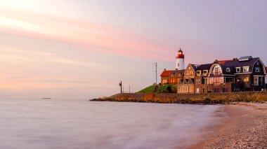 Hollanda Urk Flevoland, Hollanda 'da deniz feneriyle aydınlık bir yaz günü Ijsselmeer Gölü' nün yanındaki tarihi Urk köyünde.