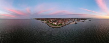 Hollanda Urk Flevoland, Hollanda 'da deniz feneriyle aydınlık bir yaz günü Ijsselmeer Gölü' nün yanındaki tarihi Urk köyünde.