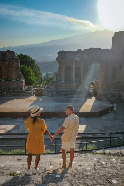 Pareja de hombres y mujeres visitan Ruinas del teatro griego antiguo en Taormina en el fondo del volcán Etna, Italia. Taormina situado en la ciudad metropolitana de Messina, en la costa este de la isla de Sicilia. — Foto de Stock