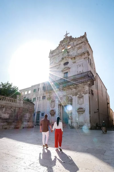 Pareja de hombres y mujeres en viaje a la ciudad Ortigia en Siracusa por la mañana. Fotografía de viaje de Siracusa, Italia en la isla de Sicilia. Catedral Plaza y mercado con protección de la cara de las personas whear — Foto de Stock