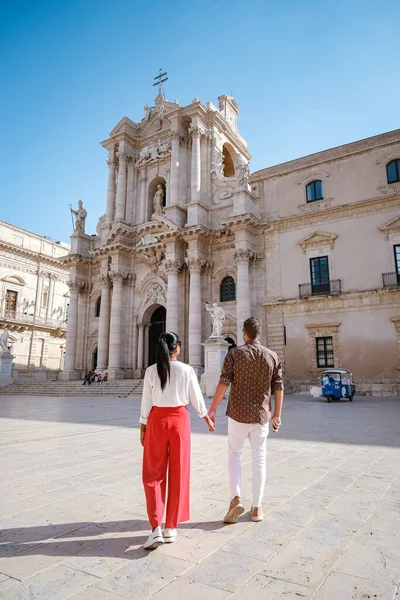 Pareja de hombres y mujeres en viaje a la ciudad Ortigia en Siracusa por la mañana. Fotografía de viaje de Siracusa, Italia en la isla de Sicilia. Catedral Plaza y mercado con protección de la cara de las personas whear — Foto de Stock