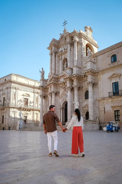 Pareja de hombres y mujeres en viaje a la ciudad Ortigia en Siracusa por la mañana. Fotografía de viaje de Siracusa, Italia en la isla de Sicilia. Catedral Plaza y mercado con protección de la cara de las personas whear — Foto de Stock