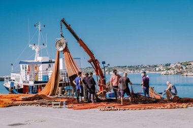 Sciacca Sicilya balıkçı tekneleri ve insanlar limanına bakan renkli Sciacca şehrinde ağları onarıyorlar. Sicilya 'nın Agrigento ili