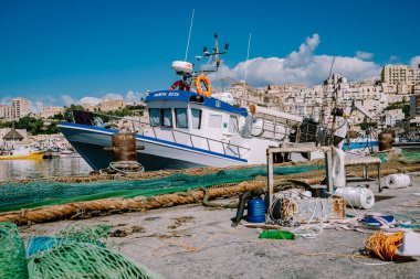 Sciacca Sicilya balıkçı tekneleri ve insanlar limanına bakan renkli Sciacca şehrinde ağları onarıyorlar. Sicilya 'nın Agrigento ili
