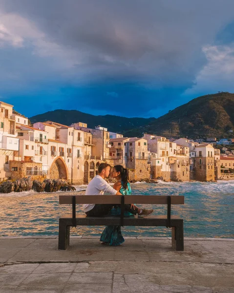 Cefalu Sicílie, pár sledující západ slunce na pláži Cefalu Sicílie Itálie, muži středního věku a žena na dovolené Sicílie — Stock fotografie