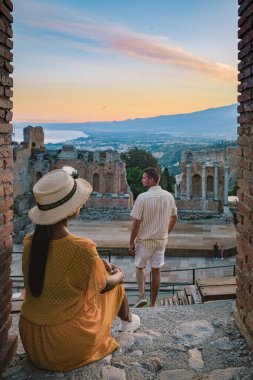 Taormina Sicilya, Sicilya, Taormina 'daki Antik Yunan Tiyatrosu' nun kalıntılarında gün batımını izleyen çift.