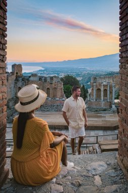 Taormina Sicilya, Sicilya, Taormina 'daki Antik Yunan Tiyatrosu' nun kalıntılarında gün batımını izleyen çift.