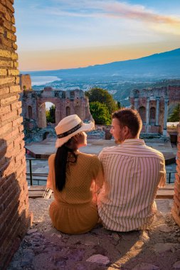 Taormina Sicilya, Sicilya, Taormina 'daki Antik Yunan Tiyatrosu' nun kalıntılarında gün batımını izleyen çift.