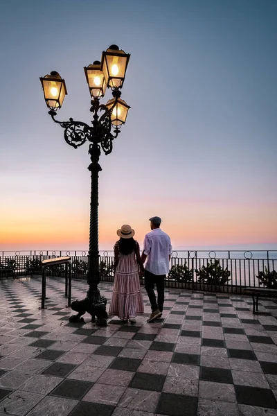 Taormina Sicilia, pareja de hombres y mujeres de mediana edad observando el amanecer en el casco antiguo de Taormina Sicilia — Foto de Stock