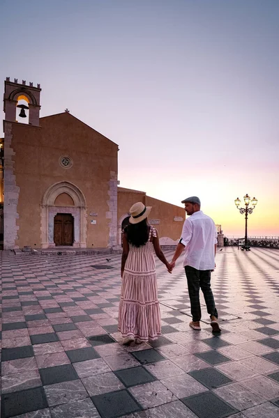 Таормина Сицилия, пара мужчин и женщин средних лет, наблюдающих за восходом солнца в старом городе Таормина Сицилия — стоковое фото