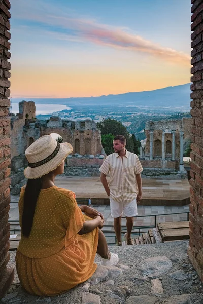 Taormina Sicílie, pár sledující západ slunce v troskách starověkého řeckého divadla v Taormině, Sicílie — Stock fotografie