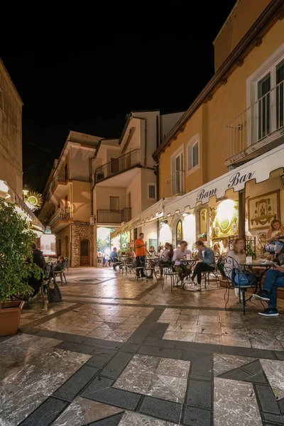 Таорміна Сицилія, старі вулиці Таорміна ввечері з увімкненим світлом і людьми на терасі. — стокове фото