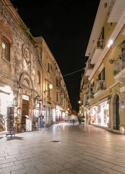 저녁에 불을 켜고 테라스에 있는 사람들과 함께 있는 타오르미나 시의 옛 거리들 — 스톡 사진