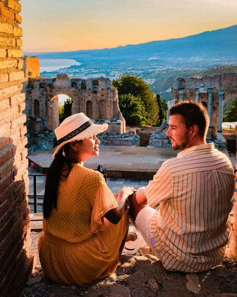 Таормина Сицилия, пара, смотрящая закат на руинах древнегреческого театра в Таормине, Сицилия — стоковое фото