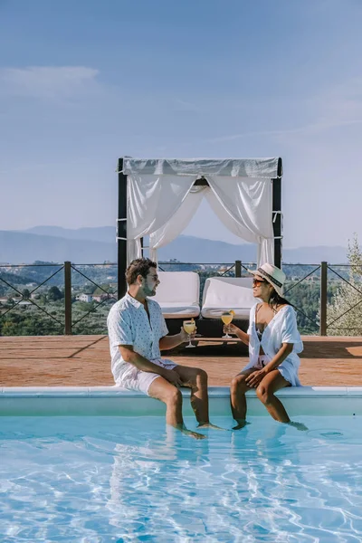 Πολυτελής εξοχική κατοικία με πισίνα στην Ιταλία, Ζευγάρι σε διακοπές σε πολυτελή βίλα στην Ιταλία, άνδρες και γυναίκες βλέποντας ηλιοβασίλεμα — Φωτογραφία Αρχείου