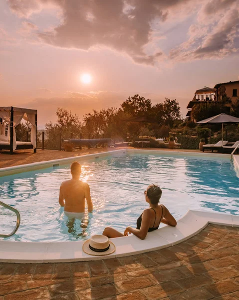 Casa de campo de lujo con piscina en Italia, Pareja de vacaciones en villa de lujo en Italia, hombres y mujeres viendo la puesta de sol —  Fotos de Stock