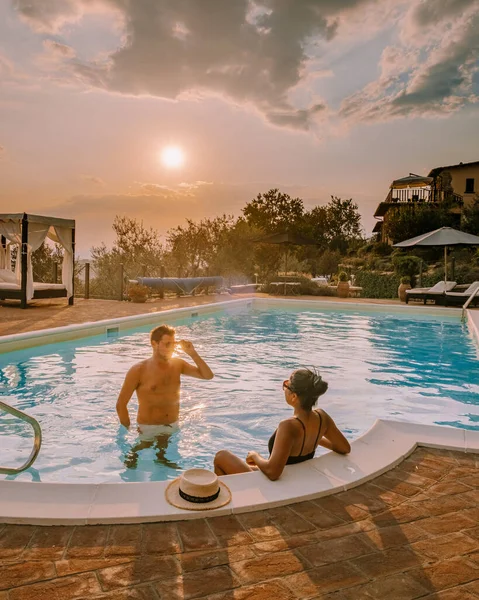 Casa de campo de lujo con piscina en Italia, Pareja de vacaciones en villa de lujo en Italia, hombres y mujeres viendo la puesta de sol —  Fotos de Stock
