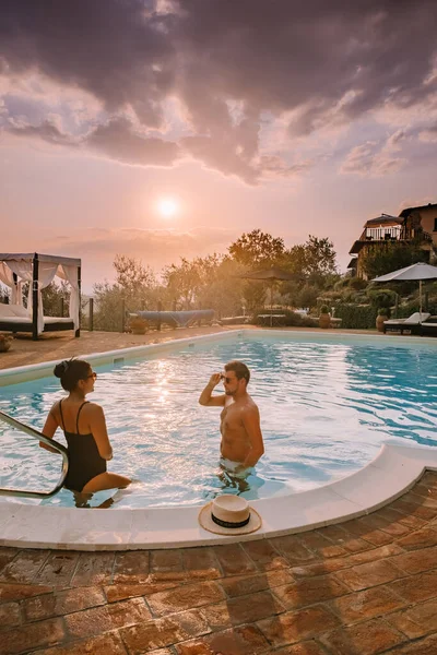 Casa di campagna di lusso con piscina in Italia, Coppia in Vacanza in villa di lusso in Italia, uomini e donne che guardano il tramonto — Foto Stock