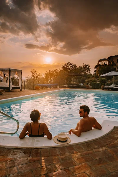 Casa de campo de lujo con piscina en Italia, Pareja de vacaciones en villa de lujo en Italia, hombres y mujeres viendo la puesta de sol —  Fotos de Stock