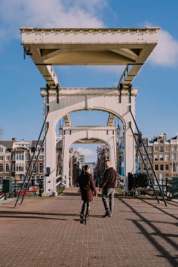 Amsterdam tarihi merkezine şehir gezisine çıkan iki erkek ve kadın Amsterdam Hollanda