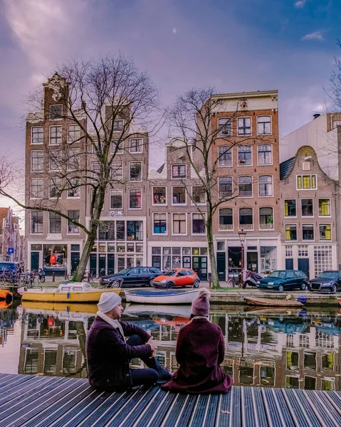Amsterdam holländische Kanäle, Paar besucht holländische Kanäle während einer Städtereise in Amsterdam, Männer und Frauen auf Städtereise in Amsterdam Niederlande — Stockfoto