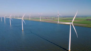 Hollanda Flevoland 'daki yel değirmeni türbinleri Hollanda' daki ijsselmeer gölünün yanındaki yeşil enerji rüzgar türbinleri.